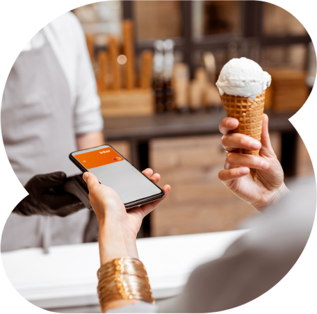 Mão de uma pessoa segurando um cartão contactless Inter laranja próximo de uma maquininha de cartão para efetivar o pagamento por aproximação.