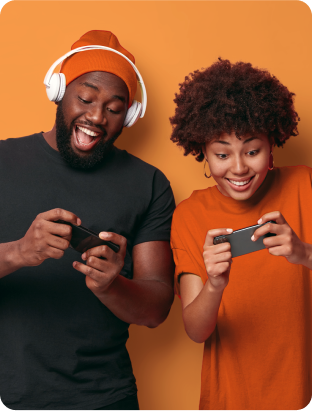 Homem e mulher sorridentes olhando para a tela do celular enquanto jogam games no celular.