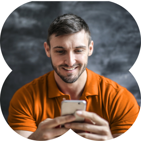 Pessoa com camisa laranja sorrindo acompanhando os investimentos no Super App do Inter